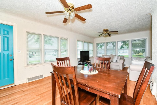 dining area with ceiling fan, a textured ceiling, and light wood-style flooring