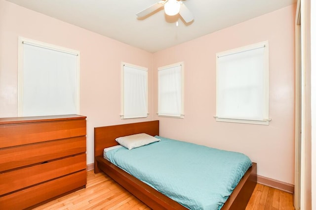 bedroom featuring light wood-style floors, baseboards, and a ceiling fan