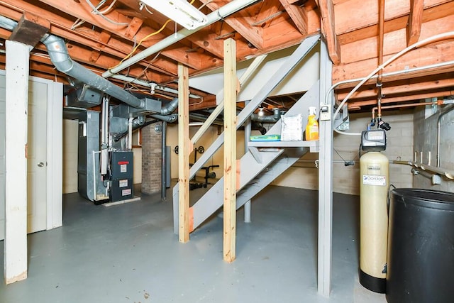 unfinished below grade area with heating unit, a water softener system, and stairs