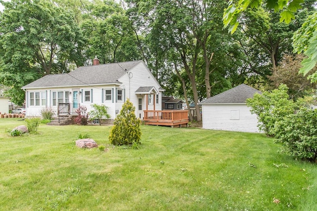 rear view of house featuring a chimney, a yard, a wooden deck, and roof with shingles