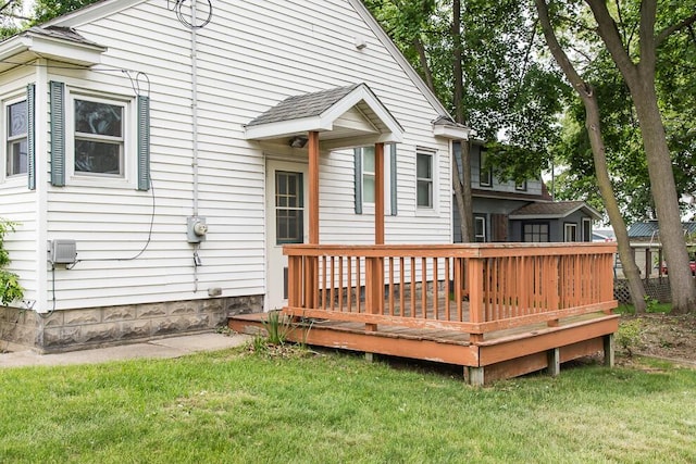 rear view of house featuring a lawn and a deck