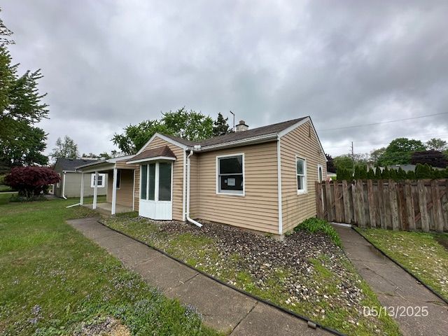 18543 Sunset St, Livonia, MI 48152 - view of front facade featuring a chimney