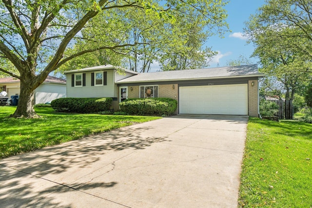 2761 Deake Ave, Ann Arbor, MI 48108 - tri-level home featuring brick siding, an attached garage, a front lawn, and concrete driveway