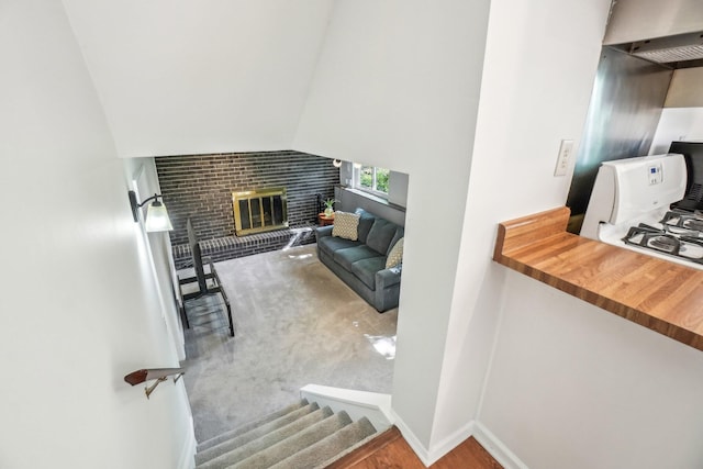 2761 Deake Ave, Ann Arbor, MI 48108 - staircase featuring a brick fireplace, baseboards, and a high ceiling