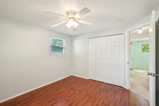 2761 Deake Ave, Ann Arbor, MI 48108 - unfurnished bedroom featuring multiple windows, dark wood-style flooring, a closet, and baseboards