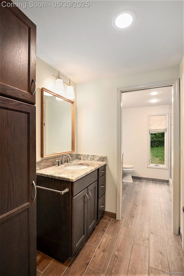 7254 Dark Lake Dr, Clarkston, MI 48346 - bathroom featuring wood finished floors, toilet, vanity, and baseboards