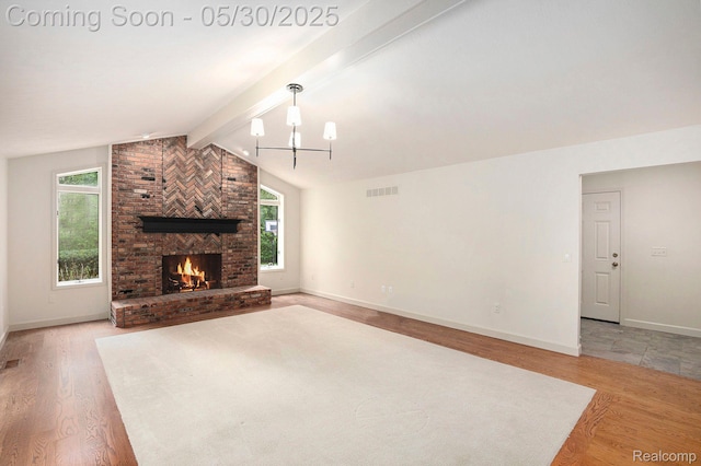 7254 Dark Lake Dr, Clarkston, MI 48346 - unfurnished living room featuring light wood-style floors, baseboards, a fireplace, and a chandelier