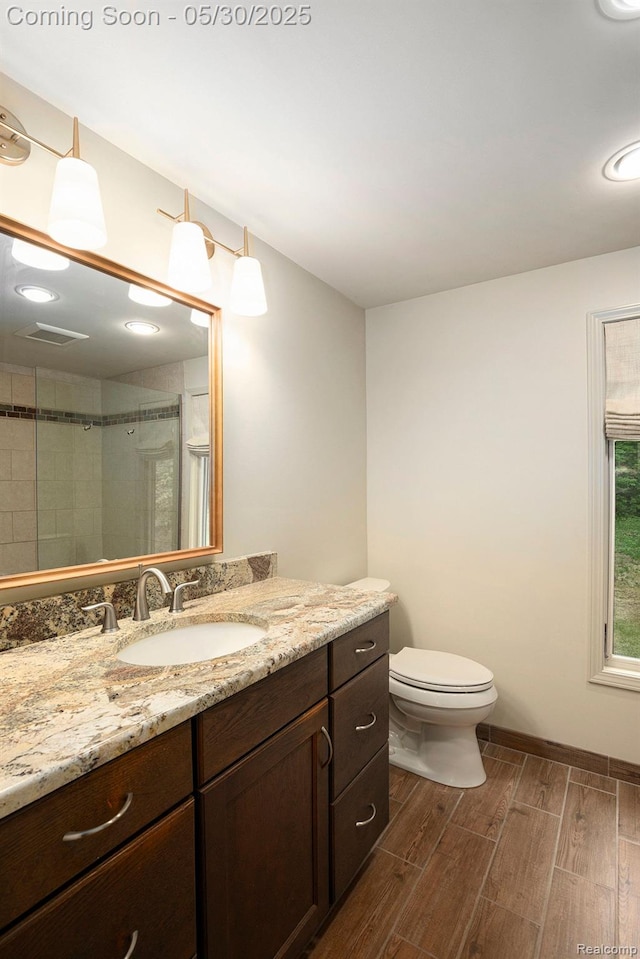 7254 Dark Lake Dr, Clarkston, MI 48346 - full bathroom featuring vanity, wood finish floors, toilet, a tile shower, and baseboards