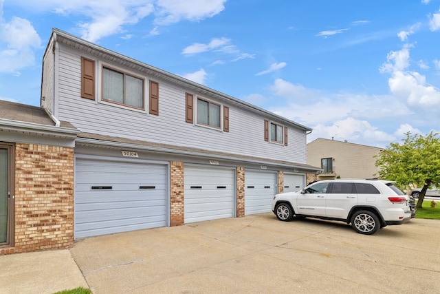 50102 S Angelo, Chesterfield, MI 48047 - townhome / multi-family property featuring brick siding, concrete driveway, and an attached garage