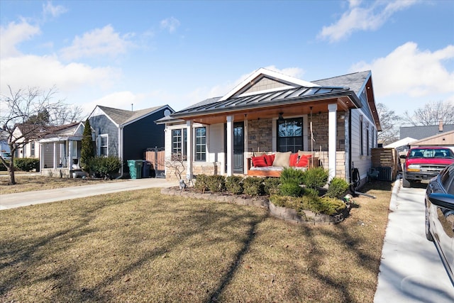 1826 Morris Ave, Lincoln Park, MI 48146 - view of front facade featuring a standing seam roof, a porch, stone siding, a front lawn, and metal roof