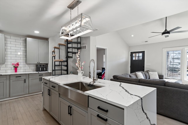 1826 Morris Ave, Lincoln Park, MI 48146 - kitchen featuring gray cabinetry, a sink, open floor plan, vaulted ceiling, and recessed lighting