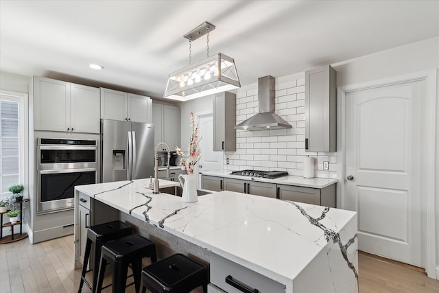 1826 Morris Ave, Lincoln Park, MI 48146 - kitchen featuring stainless steel appliances, wall chimney exhaust hood, tasteful backsplash, light stone countertops, and recessed lighting