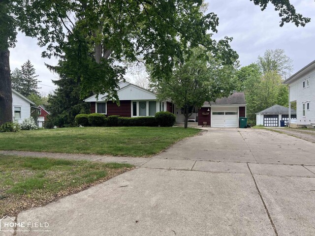 1300 N Washington St, Owosso, MI 48867 - single story home featuring a front lawn, an attached garage, and driveway