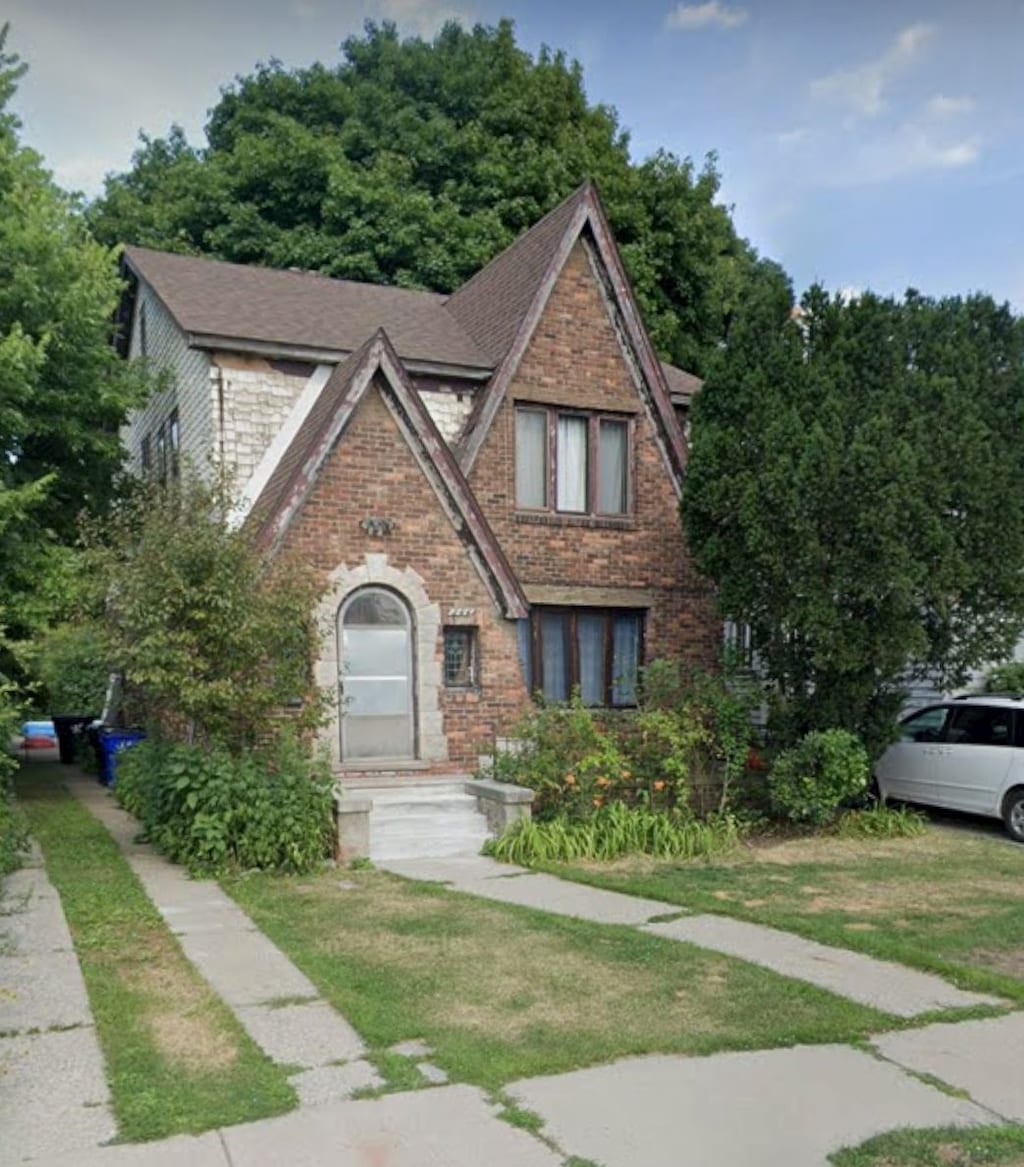 244 Lenox St NE, Detroit, MI 48215 - tudor home featuring brick siding, a front lawn, and roof with shingles