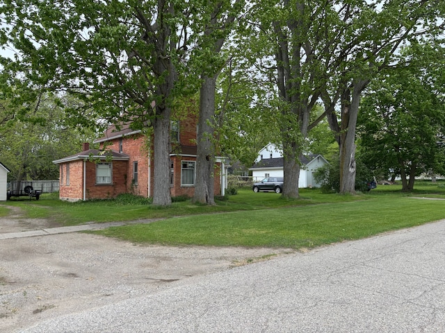 3927 W Sheldon Rd, Carsonville, MI 48419 - view of property hidden behind natural elements with brick siding, a front lawn, and dirt driveway