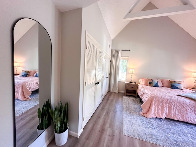 130 N Shore Dr Unit 8, South Haven, MI 49090 - bedroom featuring wood finished floors, beamed ceiling, baseboards, a closet, and high vaulted ceiling