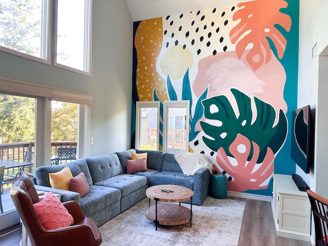 130 N Shore Dr Unit 8, South Haven, MI 49090 - living area with wallpapered walls, a towering ceiling, wood finished floors, plenty of natural light, and an accent wall