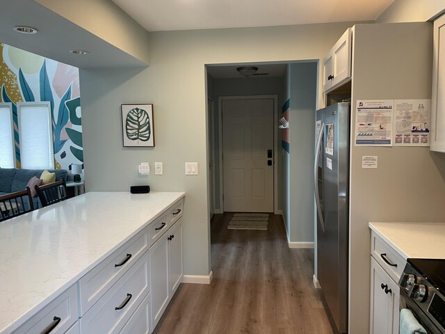 130 N Shore Dr Unit 8, South Haven, MI 49090 - kitchen with freestanding refrigerator, dark wood finished floors, black electric range, white cabinets, and light stone countertops