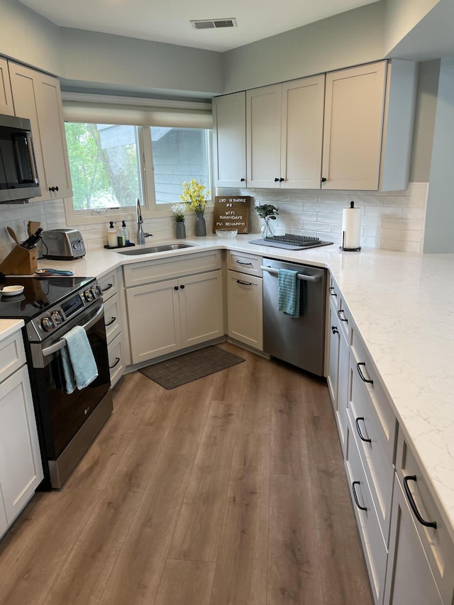 130 N Shore Dr Unit 8, South Haven, MI 49090 - kitchen with appliances with stainless steel finishes, a sink, backsplash, and dark wood-style floors