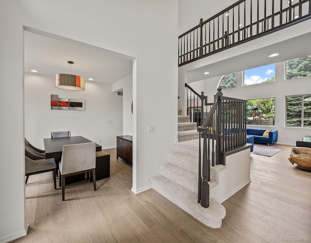 1231 Burns Dr, Troy, MI 48083 - stairway featuring wood finished floors, a towering ceiling, baseboards, and recessed lighting