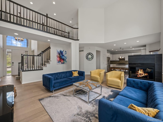 1231 Burns Dr, Troy, MI 48083 - living area with a towering ceiling, light wood-style floors, stairs, recessed lighting, and baseboards