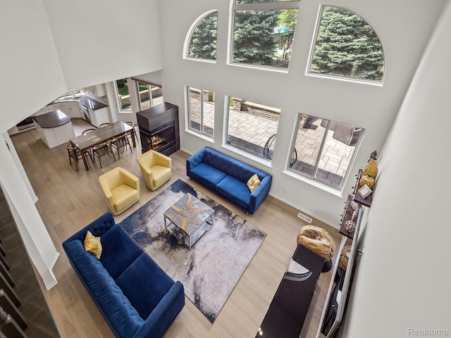 1231 Burns Dr, Troy, MI 48083 - living area featuring a high ceiling, plenty of natural light, wood finished floors, and baseboards