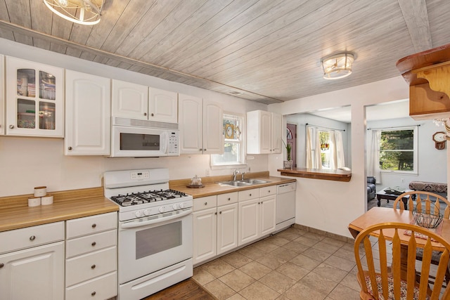 2574 S Lake Pleasant Rd, Metamora, MI 48455 - kitchen with white appliances, a sink, wood ceiling, white cabinetry, and healthy amount of natural light