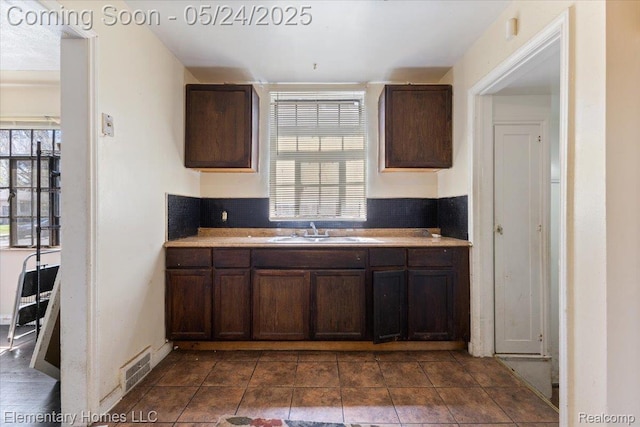 18965 Rutherford St, Detroit, MI 48235 - kitchen featuring a sink, dark brown cabinets, and decorative backsplash