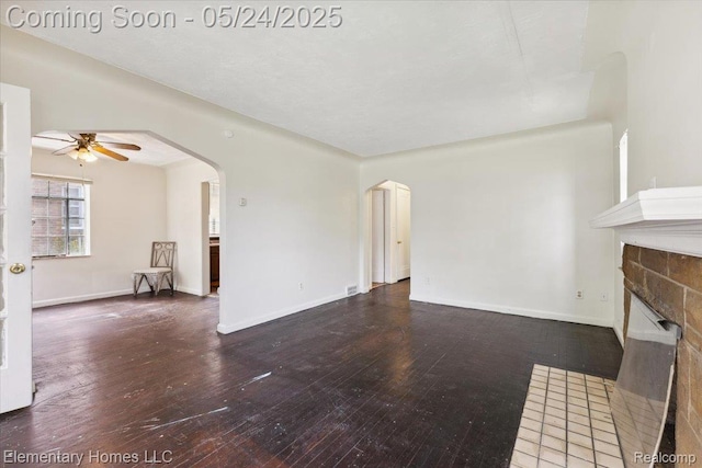 18965 Rutherford St, Detroit, MI 48235 - unfurnished living room with ceiling fan, arched walkways, a fireplace with flush hearth, wood-type flooring, and baseboards