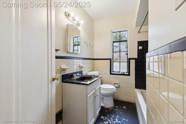 18965 Rutherford St, Detroit, MI 48235 - bathroom featuring tile walls, toilet, vanity, a tub, and a wainscoted wall