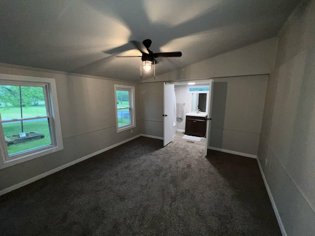 3820 Kaiser Rd, Tecumseh, MI 49286 - unfurnished bedroom with vaulted ceiling, dark carpet, baseboards, connected bathroom, and a ceiling fan