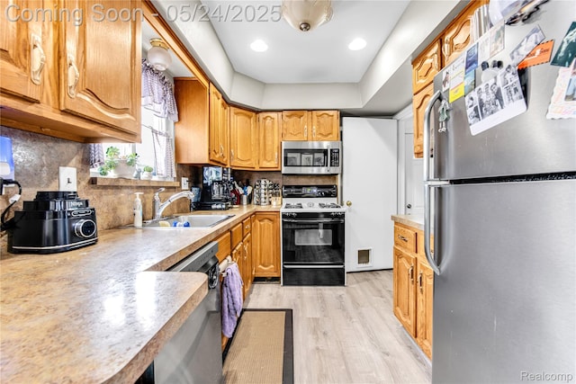 33117 Avondale St, Westland, MI 48186 - kitchen featuring stainless steel appliances, a sink, light wood finished floors, tasteful backsplash, and light countertops