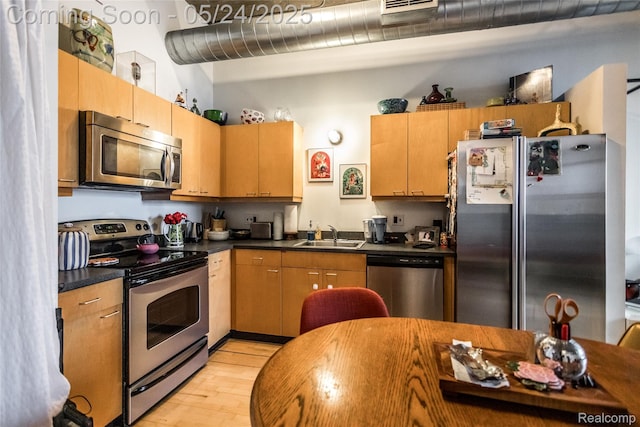 460 W Canfield St # 212/Unit 21, Detroit, MI 48201 - kitchen with stainless steel appliances, dark countertops, light wood-style floors, and a sink
