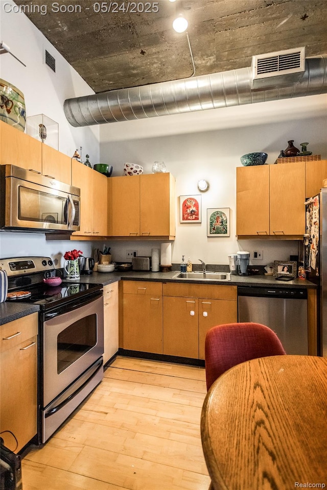 460 W Canfield St # 212/Unit 21, Detroit, MI 48201 - kitchen featuring stainless steel appliances, a sink, light wood-style floors, and dark countertops