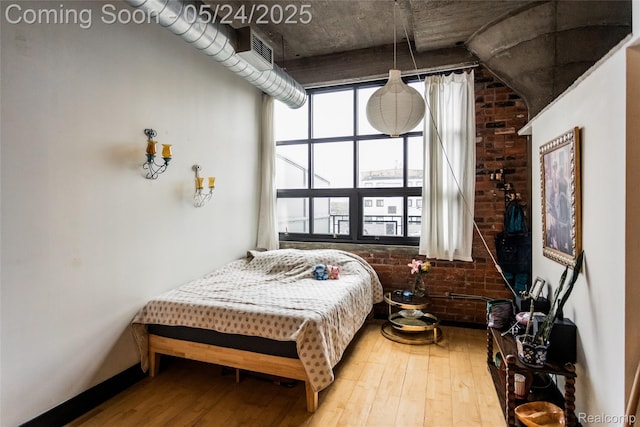 460 W Canfield St # 212/Unit 21, Detroit, MI 48201 - bedroom featuring hardwood / wood-style floors, brick wall, and baseboards