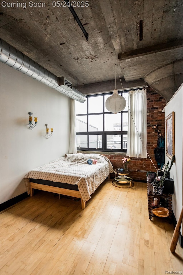 460 W Canfield St # 212/Unit 21, Detroit, MI 48201 - bedroom with wood-type flooring and brick wall