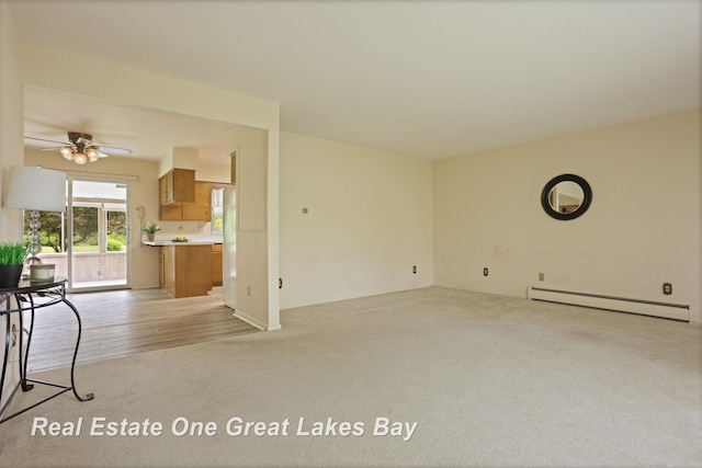 5354 N River Rd, Freeland, MI 48623 - unfurnished living room with a baseboard heating unit, light colored carpet, and a ceiling fan