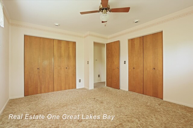 5354 N River Rd, Freeland, MI 48623 - unfurnished bedroom with multiple closets, carpet floors, and ceiling fan