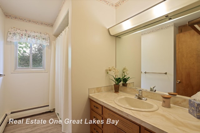 5354 N River Rd, Freeland, MI 48623 - bathroom with baseboard heating, vanity, and wood finished floors