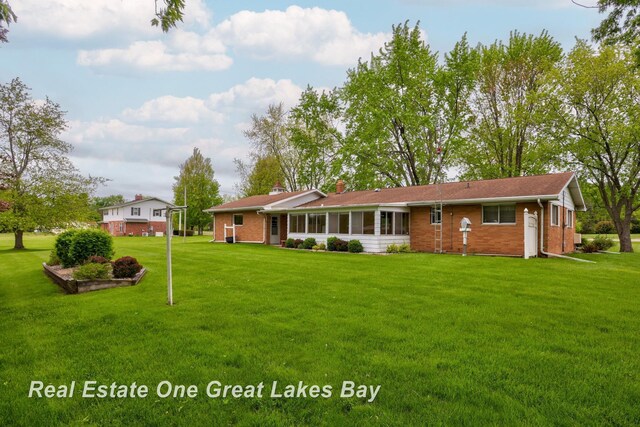 5354 N River Rd, Freeland, MI 48623 - back of property with brick siding, a yard, and a chimney
