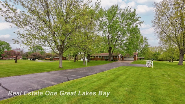 5354 N River Rd, Freeland, MI 48623 - view of front of home with asphalt driveway, an attached garage, and a front lawn