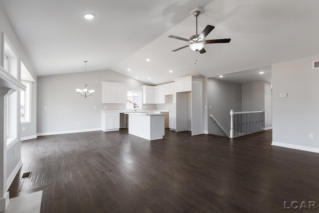 796 War Bonnet Dr, Tecumseh, MI 49286 - unfurnished living room with vaulted ceiling, recessed lighting, ceiling fan, dark wood-type flooring, and a chandelier