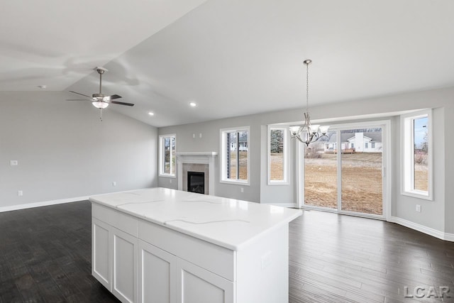 796 War Bonnet Dr, Tecumseh, MI 49286 - kitchen with open floor plan, a chandelier, a glass covered fireplace, dark wood-type flooring, and a center island