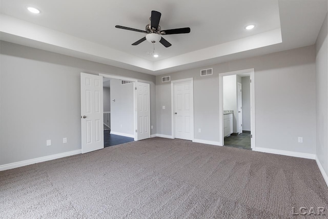 796 War Bonnet Dr, Tecumseh, MI 49286 - unfurnished bedroom featuring a raised ceiling, recessed lighting, dark carpet, baseboards, and ensuite bath