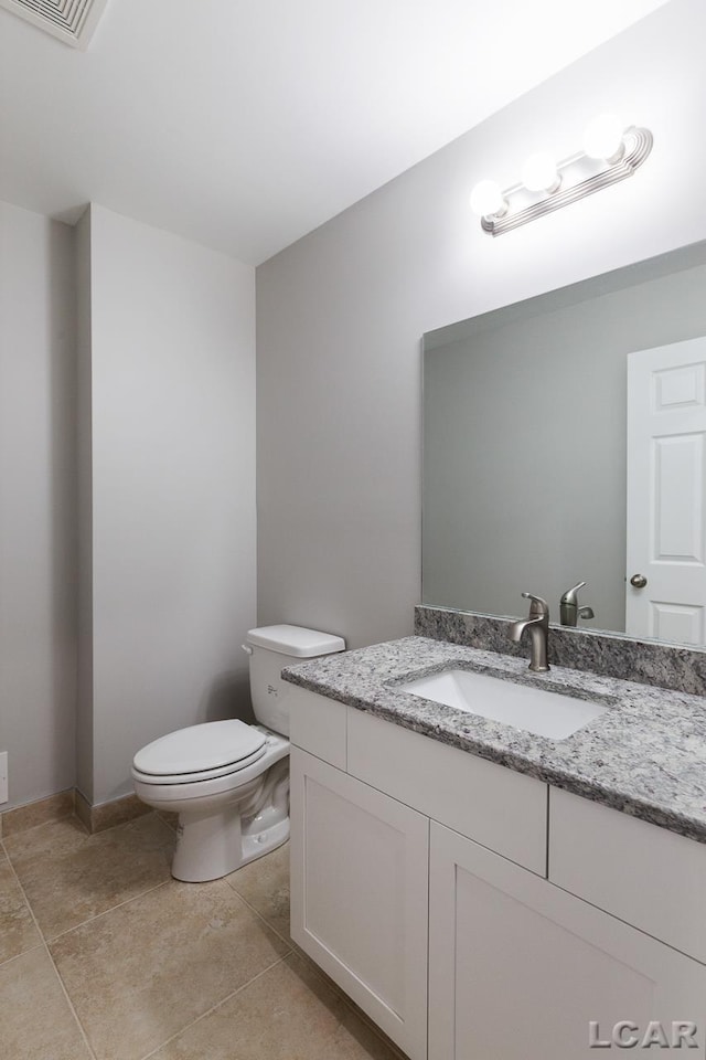 796 War Bonnet Dr, Tecumseh, MI 49286 - bathroom with toilet, vanity, and tile patterned floors