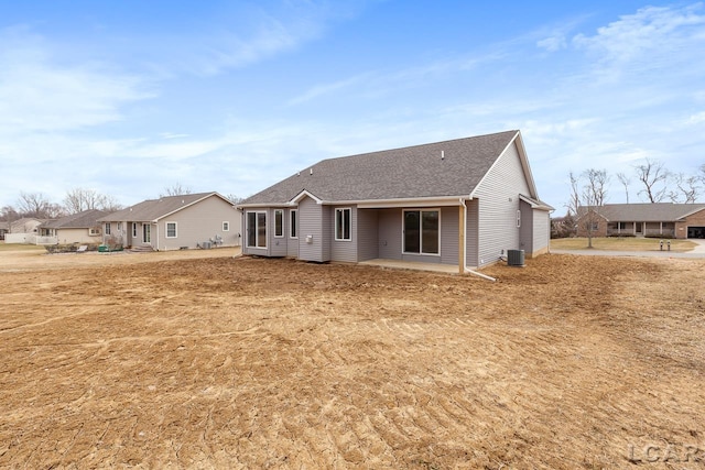 796 War Bonnet Dr, Tecumseh, MI 49286 - back of house featuring cooling unit, a shingled roof, a patio, and a residential view