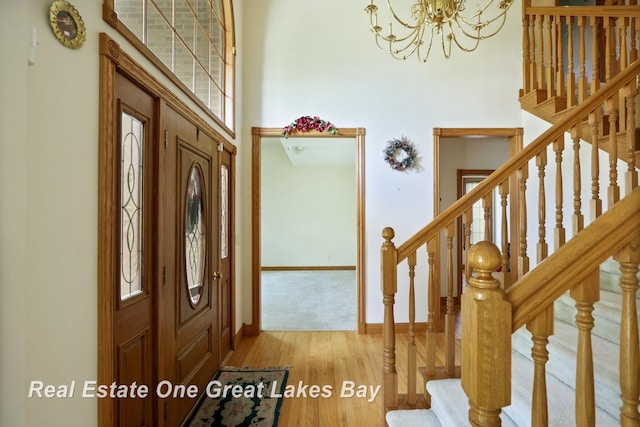 4168 Windemere Dr, Saginaw, MI 48603 - entryway with a towering ceiling, stairway, a chandelier, wood finished floors, and baseboards