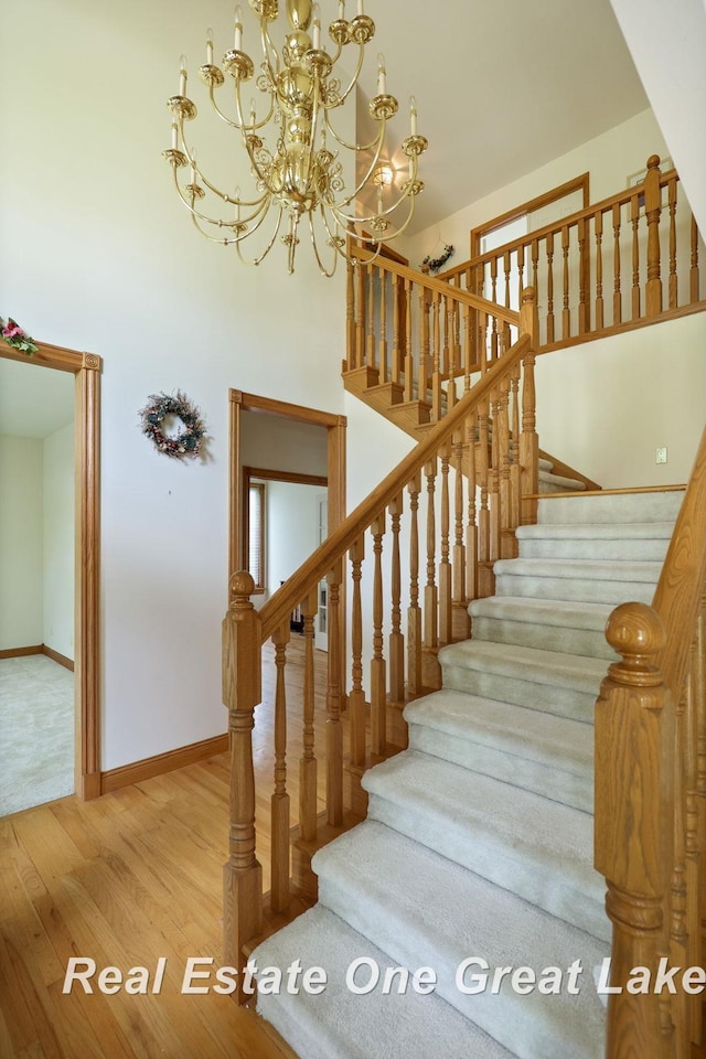 4168 Windemere Dr, Saginaw, MI 48603 - stairs with wood finished floors, a chandelier, and baseboards