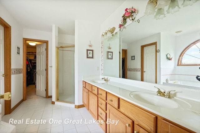 4168 Windemere Dr, Saginaw, MI 48603 - bathroom with a shower stall, tile patterned flooring, double vanity, and a walk in closet