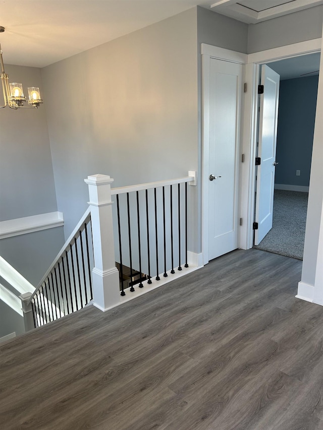 hallway featuring an upstairs landing, wood finished floors, a chandelier, and baseboards